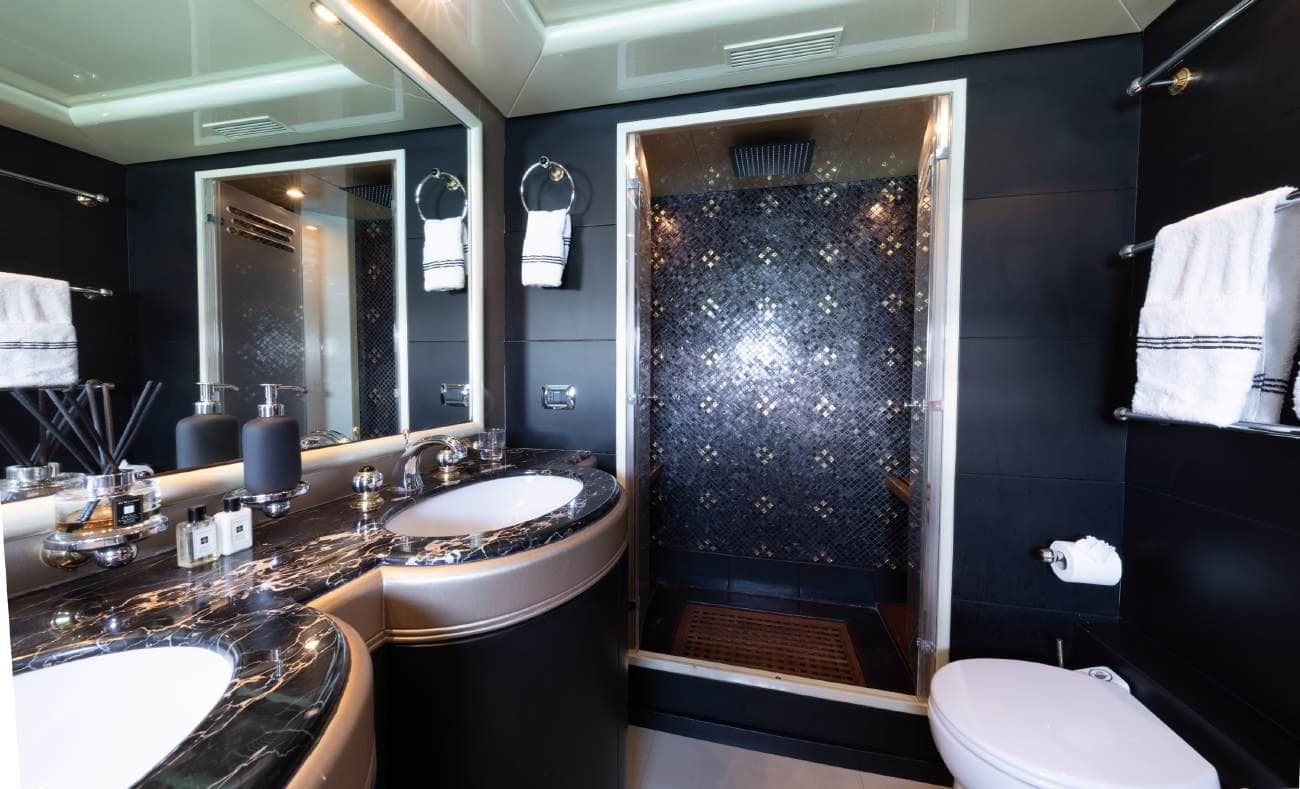 Master bathroom with dual sinks and black mosaic shower