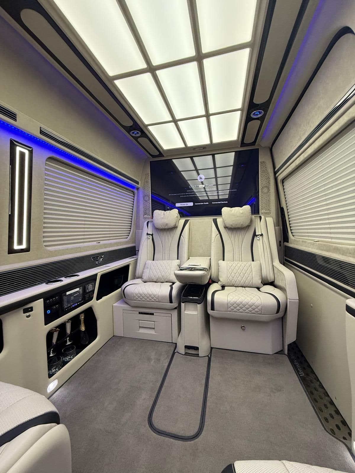 Salon ivoire du Mercedes Sprinter VIP First Class avec plafond lumineux et fauteuils inclinables électriques