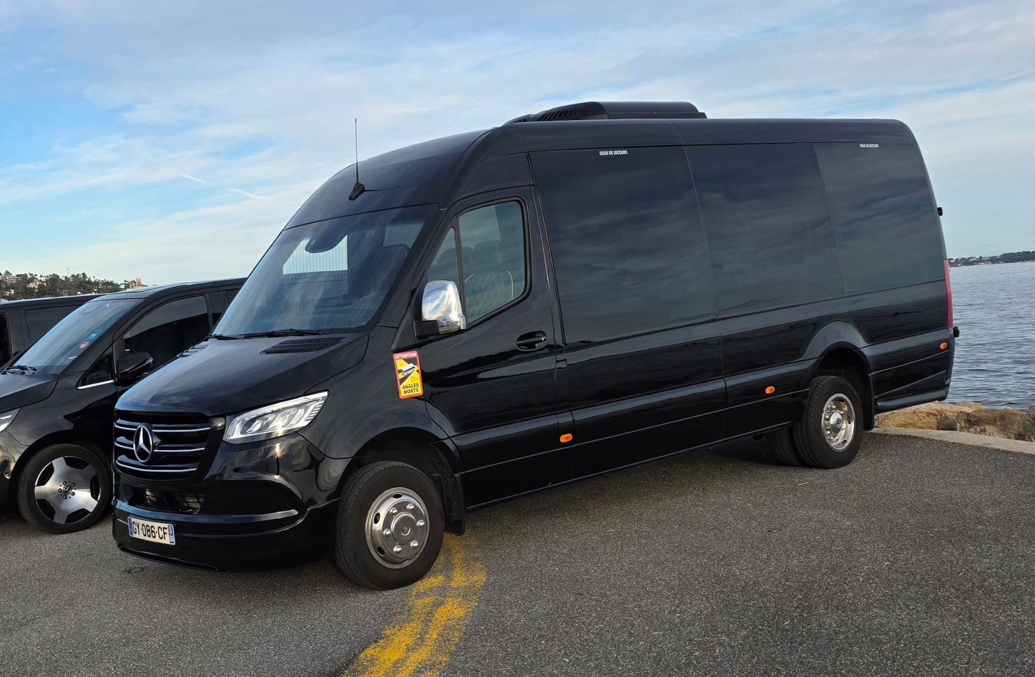 Black Mercedes Sprinter VIP minibus parked on the Saint-Tropez waterfront for a bachelor party group transfer